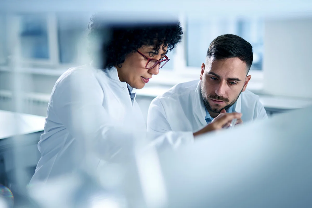 Two people in lab coats talking