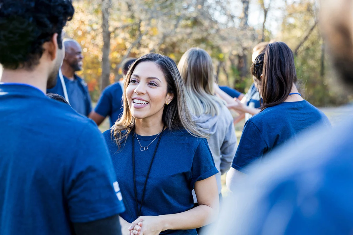Woman in blue tshirt smiling amongst crowd
